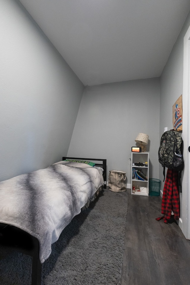 bedroom with lofted ceiling and dark hardwood / wood-style flooring