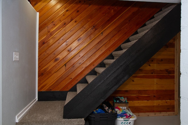 staircase featuring wood walls