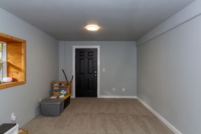 interior space with a textured ceiling and carpet floors