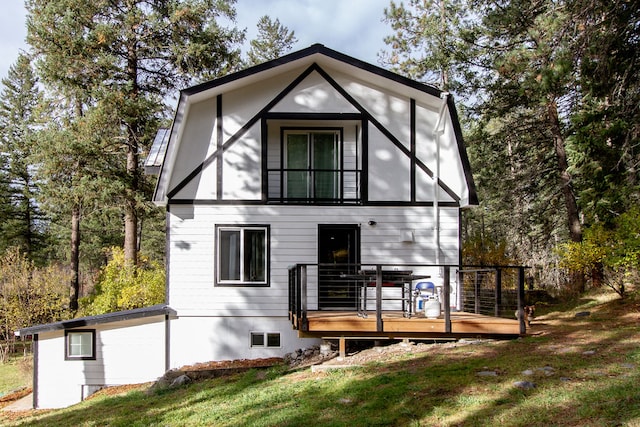 rear view of property featuring a yard and a wooden deck