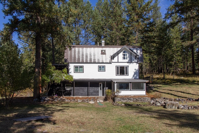 view of front facade with a front yard and a sunroom