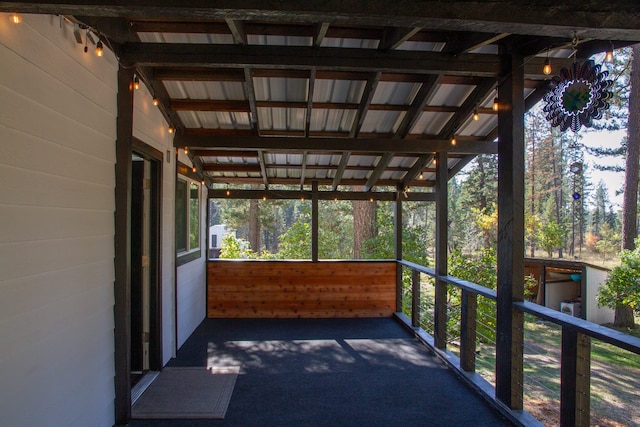 unfurnished sunroom with lofted ceiling with beams