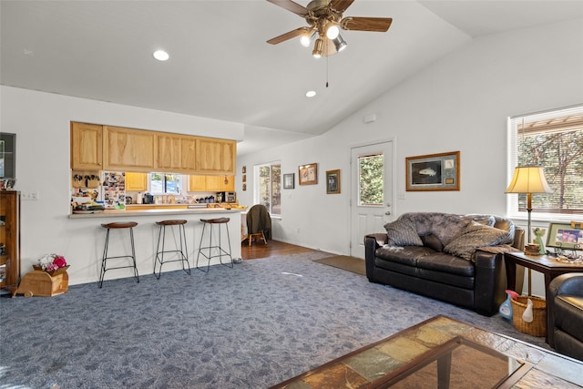 living room featuring ceiling fan, wood-type flooring, and vaulted ceiling