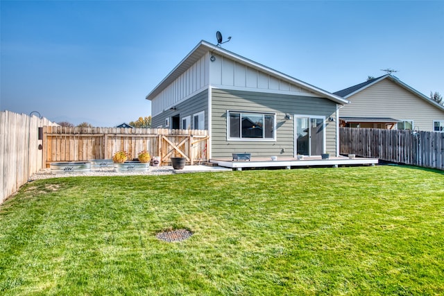 rear view of property featuring a yard and a wooden deck