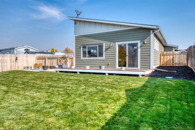 back of house featuring a yard and a wooden deck