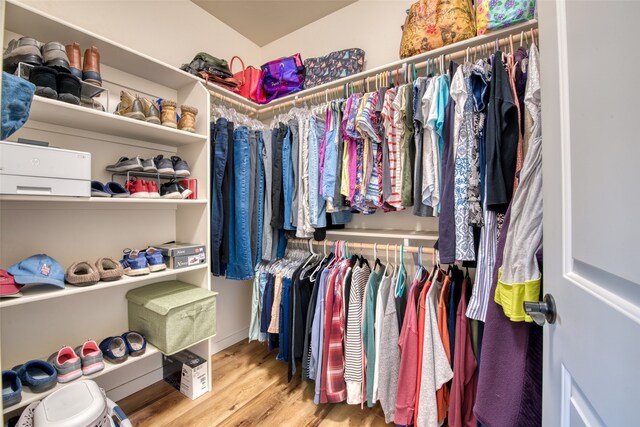 walk in closet with light hardwood / wood-style flooring