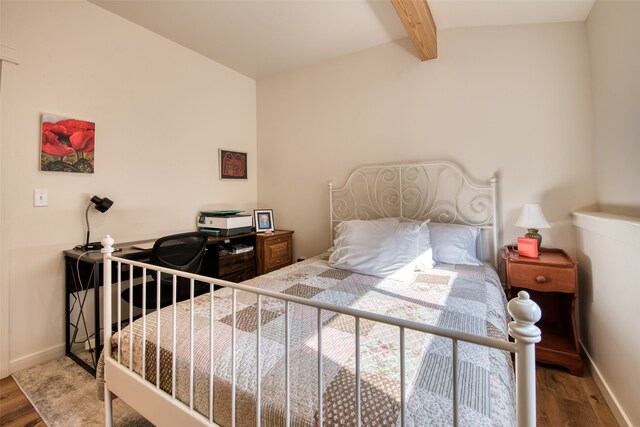 bedroom with vaulted ceiling with beams and hardwood / wood-style flooring