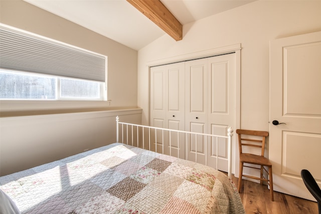 bedroom with vaulted ceiling with beams, a closet, and hardwood / wood-style floors