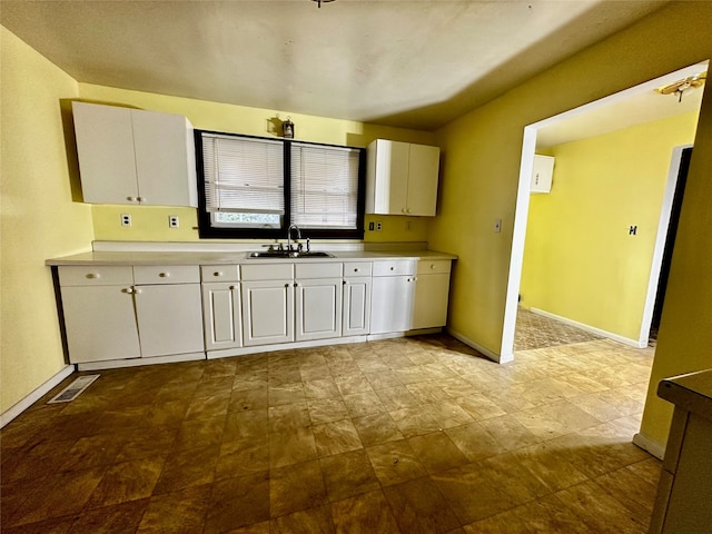 kitchen featuring white cabinetry and sink