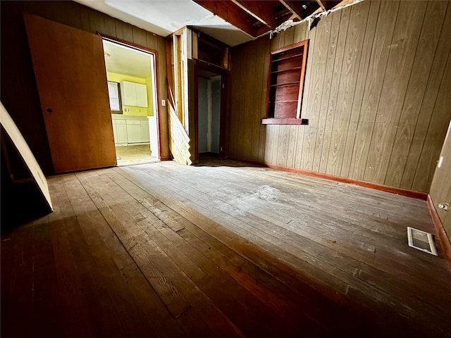 spare room with wood-type flooring and wood walls