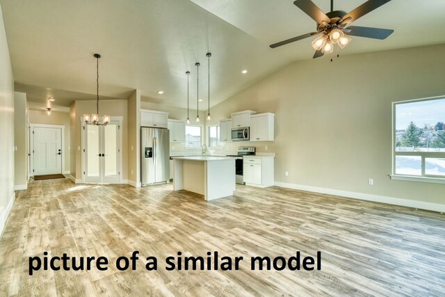 kitchen with a kitchen island, vaulted ceiling, pendant lighting, white cabinetry, and appliances with stainless steel finishes