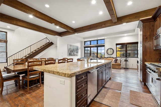 89 Slopeside Dr Unit 4, Whitefish, MT 59937 - kitchen with stainless steel appliances, open floor plan, beamed ceiling, a sink, and dark wood finished floors