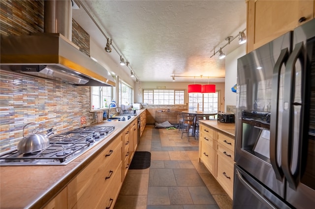 kitchen with exhaust hood, appliances with stainless steel finishes, decorative backsplash, and a textured ceiling