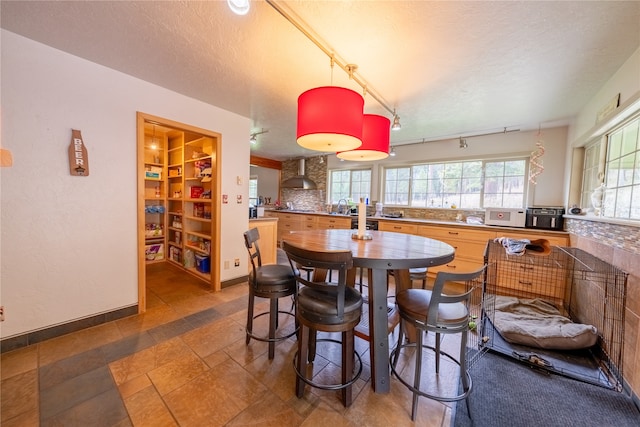 dining room featuring sink, track lighting, and a textured ceiling