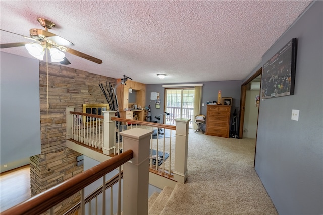 hall featuring light carpet and a textured ceiling