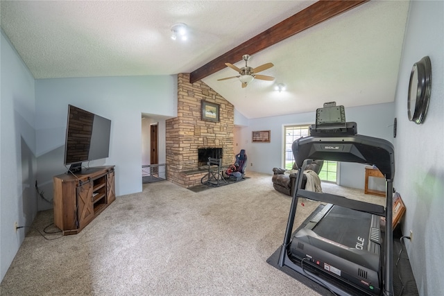 exercise room featuring carpet flooring, a stone fireplace, a textured ceiling, ceiling fan, and lofted ceiling