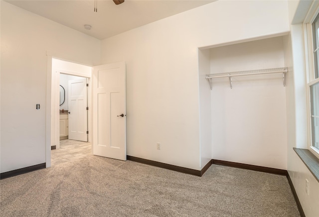 unfurnished bedroom featuring ceiling fan, a closet, and light colored carpet