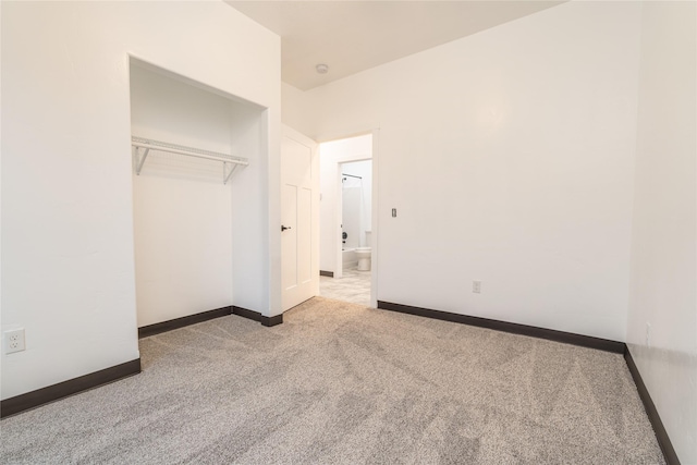 unfurnished bedroom featuring a closet and light colored carpet