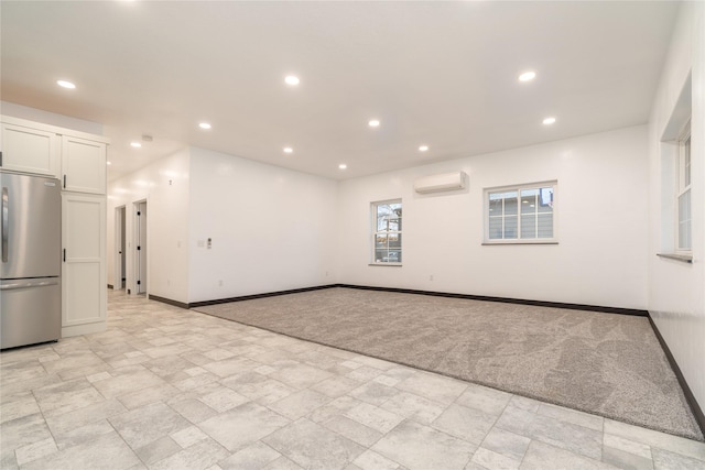 interior space with a wall mounted AC and light colored carpet