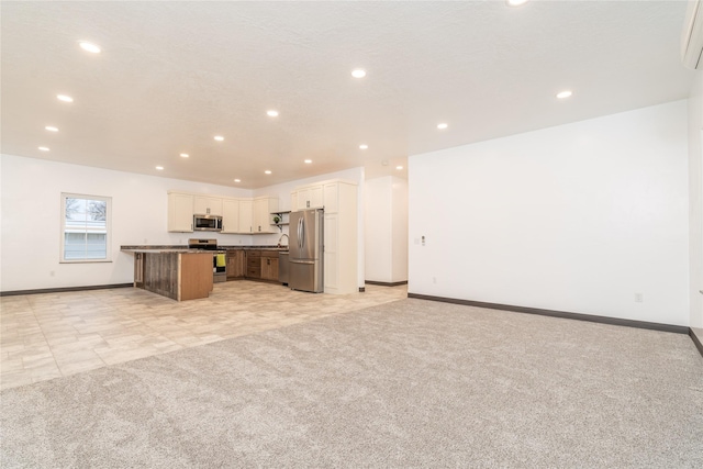 kitchen featuring white cabinetry, a center island, stainless steel appliances, light colored carpet, and a breakfast bar