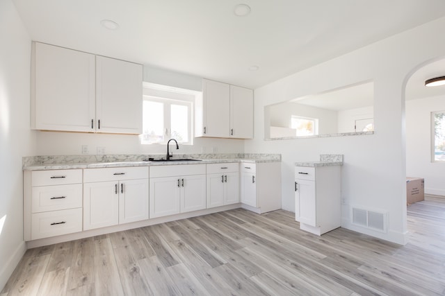 kitchen featuring sink, white cabinetry, and light hardwood / wood-style floors