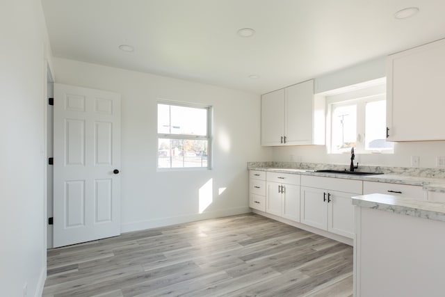 kitchen with sink, white cabinetry, and light wood-type flooring