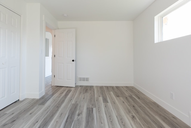 unfurnished room with light wood-type flooring