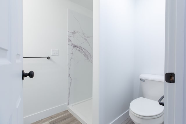 bathroom featuring toilet, hardwood / wood-style floors, and walk in shower