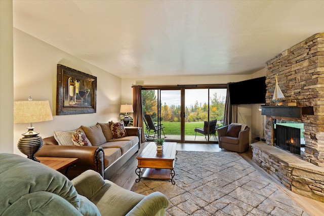 living room featuring a stone fireplace and light wood-type flooring