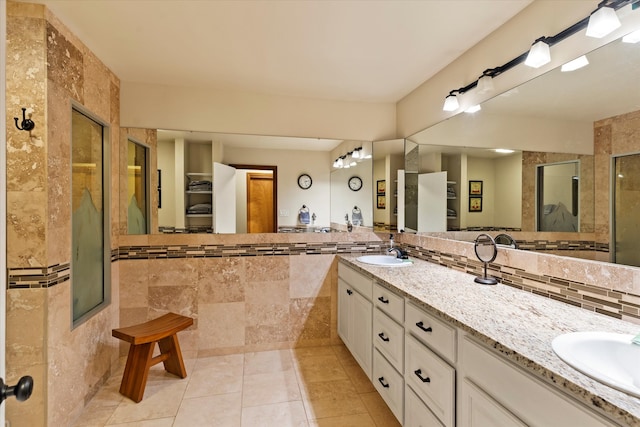 bathroom with vanity, tile patterned floors, tile walls, and a shower with shower door