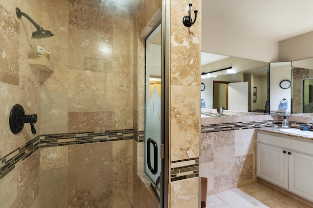 bathroom with vanity, tile patterned flooring, tile walls, and a shower with door