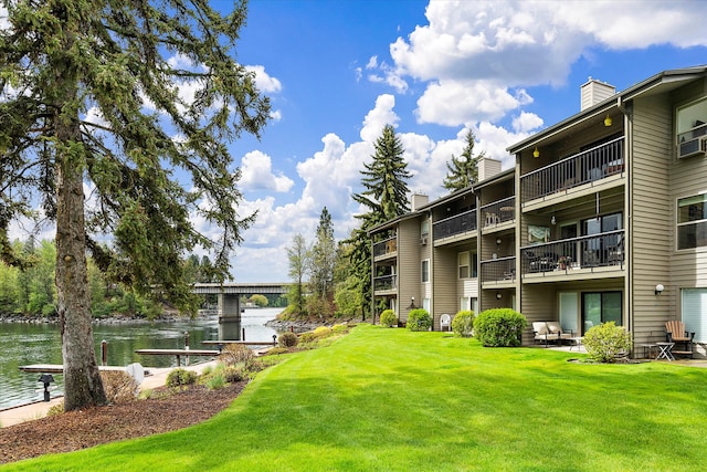 surrounding community featuring a patio, a lawn, and a water view