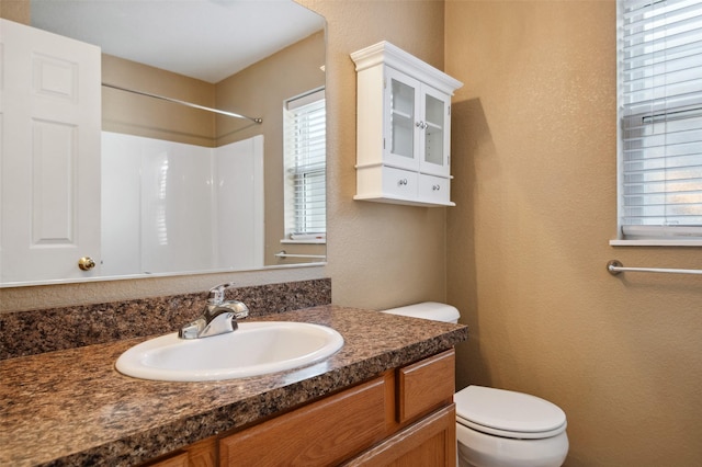 bathroom with vanity, toilet, and walk in shower