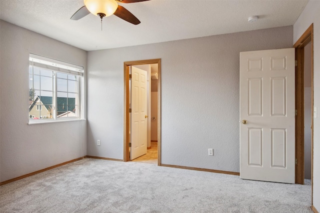 unfurnished bedroom with ceiling fan and light carpet