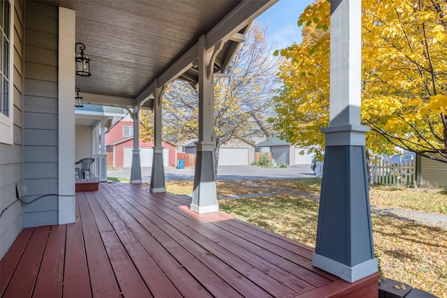 wooden terrace with covered porch and a garage