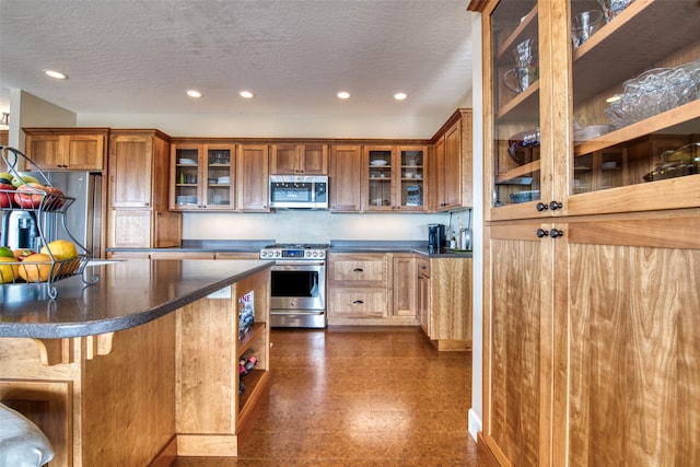 kitchen featuring a textured ceiling, a kitchen bar, and stainless steel appliances