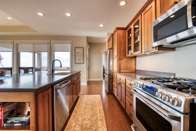 kitchen featuring a textured ceiling, premium appliances, and sink