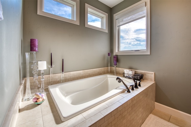 bathroom with tile patterned flooring and a relaxing tiled tub