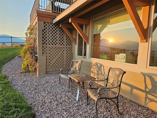 patio terrace at dusk featuring a balcony