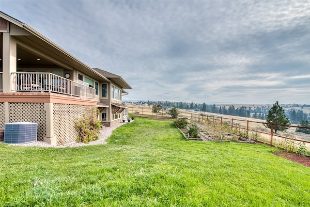 view of yard with a rural view, central AC, and a wooden deck