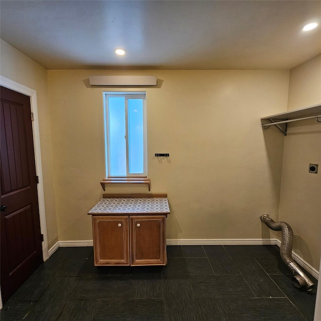 washroom featuring cabinets, hookup for an electric dryer, and a wall mounted air conditioner