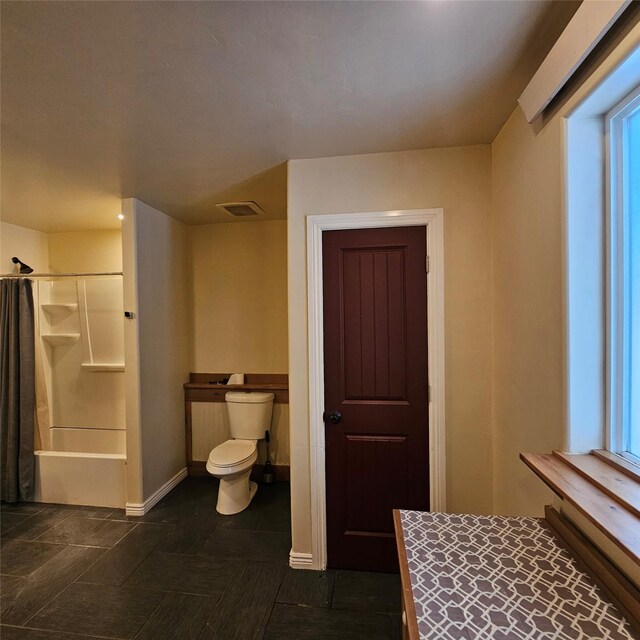 bathroom with toilet and shower / bath combo with shower curtain