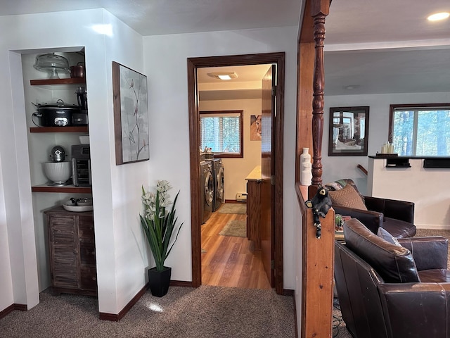 corridor with washing machine and clothes dryer and light hardwood / wood-style floors