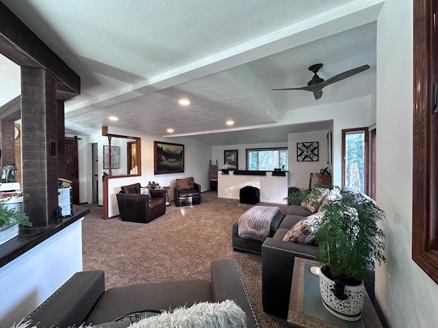 living room featuring carpet flooring, ceiling fan, a barn door, and a textured ceiling