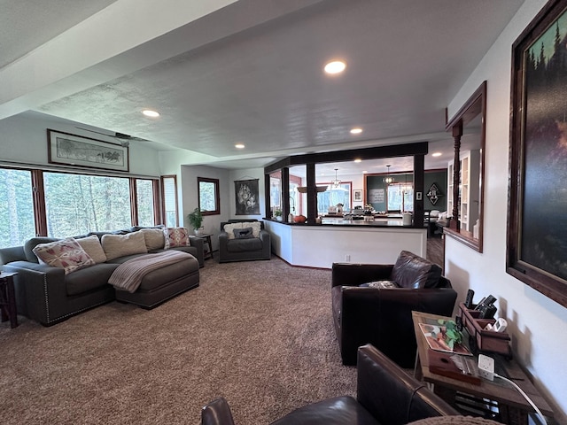 carpeted living room with decorative columns