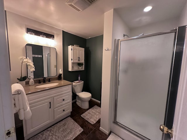 bathroom with tile patterned flooring, vanity, toilet, and a shower with door