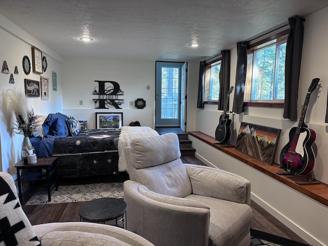 bedroom with hardwood / wood-style floors, a textured ceiling, and access to outside