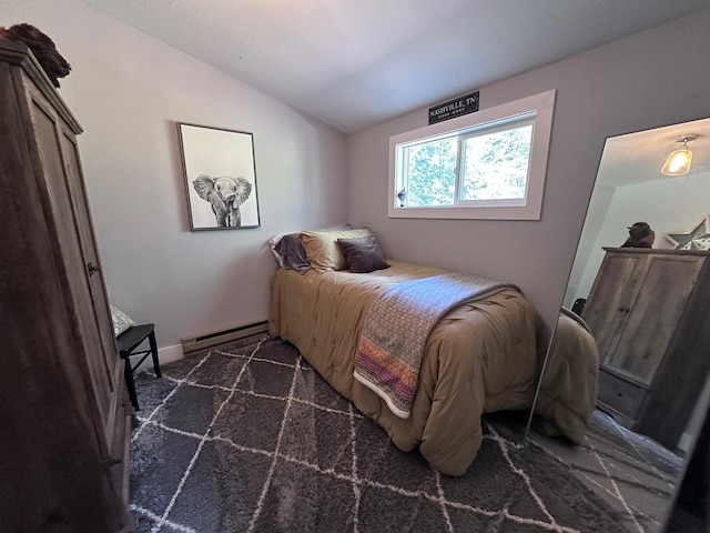 bedroom with a baseboard radiator, lofted ceiling, and dark colored carpet