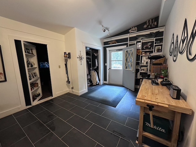 tiled foyer entrance featuring vaulted ceiling