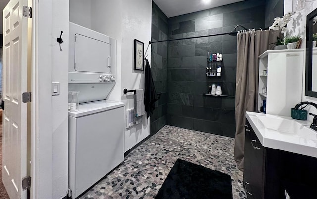 bathroom featuring a shower with curtain, stacked washer and dryer, and vanity